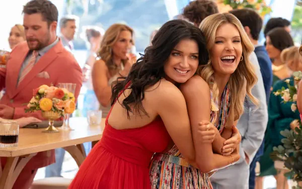 Eve Hewson and Meghann Fahy share a joyful moment together at a lively gathering in this HD wallpaper from the TV show The Perfect Couple.