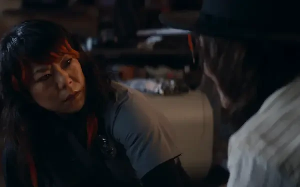 A tense moment from a TV show, featuring two characters engaged in a serious conversation, captures the intrigue of Agatha All Along. This HD image serves as a striking desktop wallpaper.