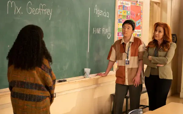 A scene from the TV show Abbott Elementary, featuring characters discussing at a chalkboard in a classroom setting, reflecting the show's humor and educational themes.