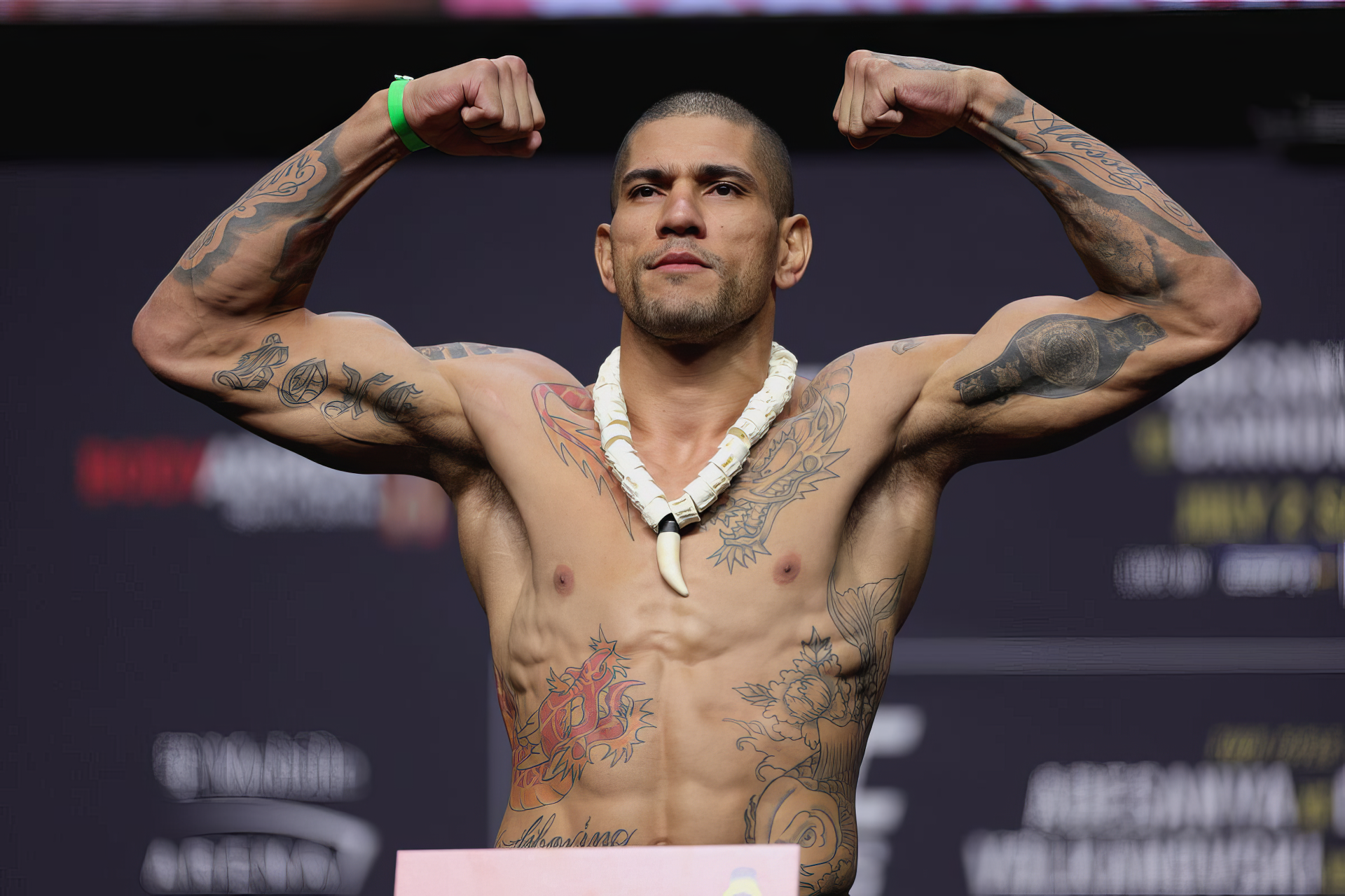 Alex Pereira flexes his muscles at an MMA weigh-in, showcasing his tattoos and physique, making for a striking HD desktop wallpaper background for UFC fans.