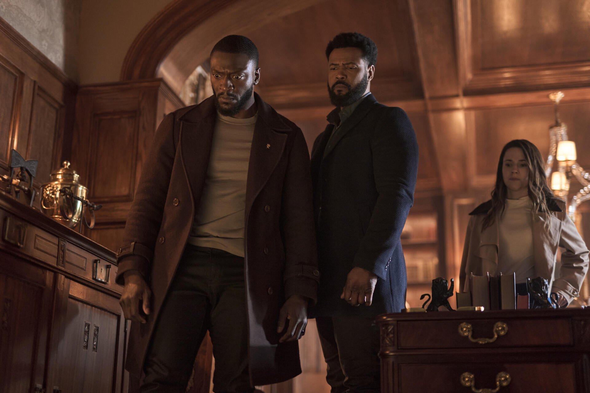 Aldis Hodge and Isaiah Mustafa stand confidently in a richly detailed office setting from the TV show Cross (2024), creating a captivating background for any device.