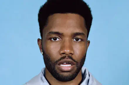 Close-up of Frank Ocean, featuring his expressive gaze against a light blue background. This HD wallpaper captures the essence of the artist and complements any music-themed desktop.