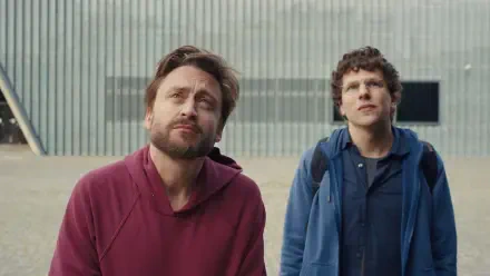 Kieran Culkin and Jesse Eisenberg look up thoughtfully in a scene from the movie A Real Pain, featured as a striking HD desktop wallpaper.