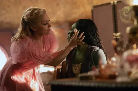 Ariana Grande and Cynthia Erivo in a scene from the movie Wicked, showcasing a vibrant moment between their characters, set in a beautifully designed interior.