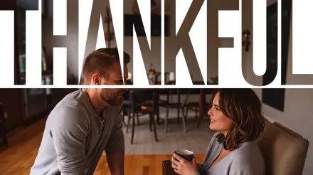 A cozy scene featuring two people engaged in conversation, set against a backdrop that prominently displays the word THANKFUL. This 4K Ultra HD wallpaper captures warmth and gratitude.