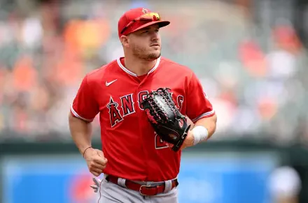 Mike Trout of the Los Angeles Angels in his red uniform, focused on the game, ready with his glove. A dynamic baseball moment captured for fans and sports enthusiasts.