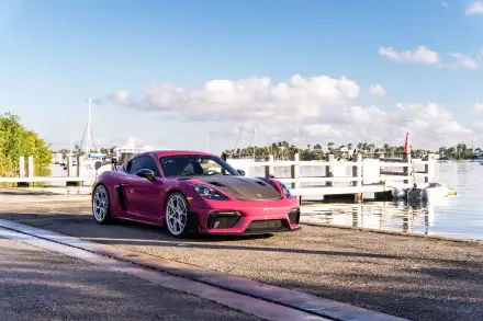 8K Ultra HD PC desktop wallpaper of a purple-red Porsche sports car parked by a marina under a bright blue sky — car, Porsche, background
