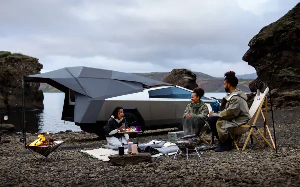 A Tesla Cybertruck parked by a scenic lake, with three people enjoying a cozy outdoor gathering on the shore, surrounded by rocky terrain under a cloudy sky. 4K Ultra HD quality.