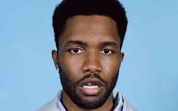 Close-up of Frank Ocean, featuring his expressive gaze against a light blue background. This HD wallpaper captures the essence of the artist and complements any music-themed desktop.