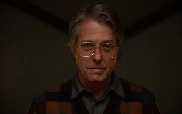 Hugh Grant stars in Heretic (2024), depicted here in a dramatic 4K Ultra HD Desktop Wallpaper, showcasing his intense expression and distinctive style.