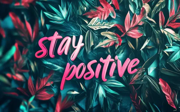 A vibrant HD desktop wallpaper featuring lush leaves in shades of green and pink, emblazoned with the motivational quote stay positive.