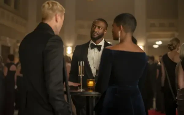 Aldis Hodge appears in a sophisticated scene from the TV show Cross (2024), engaging in conversation at a formal event surrounded by elegantly dressed attendees.