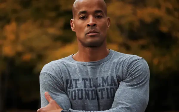 High-definition desktop wallpaper features David Goggins, a prominent figure in sports, showcasing determination and resilience against a backdrop of autumn colors.