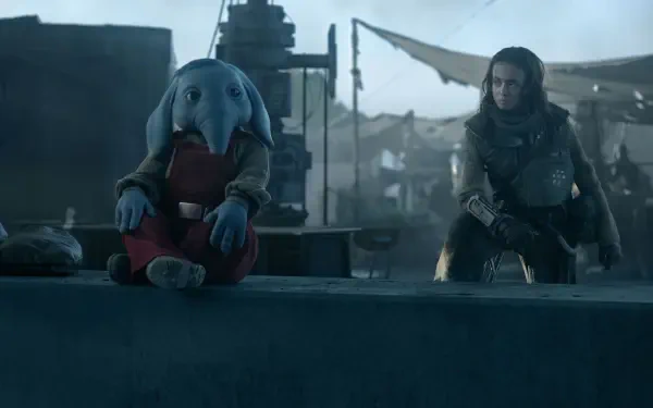 A scene from the TV show Star Wars: Skeleton Crew, featuring a unique character with blue skin and large ears sitting beside a companion in a mysterious setting. 4K Ultra HD wallpaper.