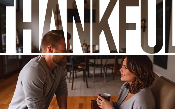 A cozy scene featuring two people engaged in conversation, set against a backdrop that prominently displays the word THANKFUL. This 4K Ultra HD wallpaper captures warmth and gratitude.