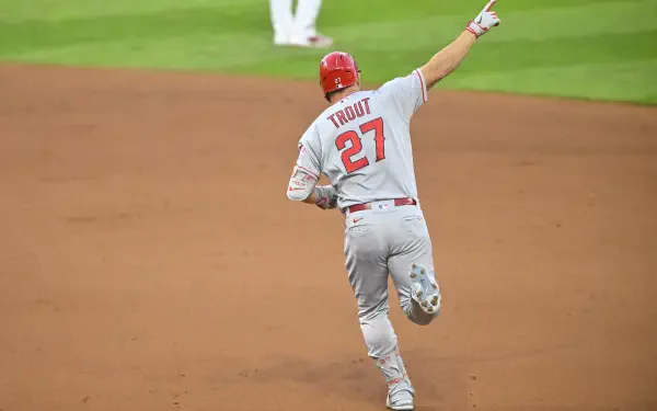 Mike Trout of the Los Angeles Angels celebrates during a game, wearing his Grey uniform with the number 27. A dynamic HD wallpaper capturing the spirit of MLB baseball.