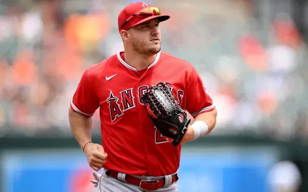 Mike Trout of the Los Angeles Angels in his red uniform, focused on the game, ready with his glove. A dynamic baseball moment captured for fans and sports enthusiasts.