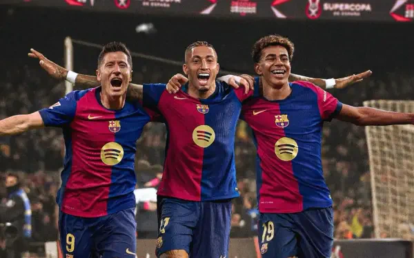 Lamine Yamal, Robert Lewandowski, and Raphael Dias Belloli celebrate on the field in vibrant FC Barcelona kits in this HD PC desktop wallpaper.