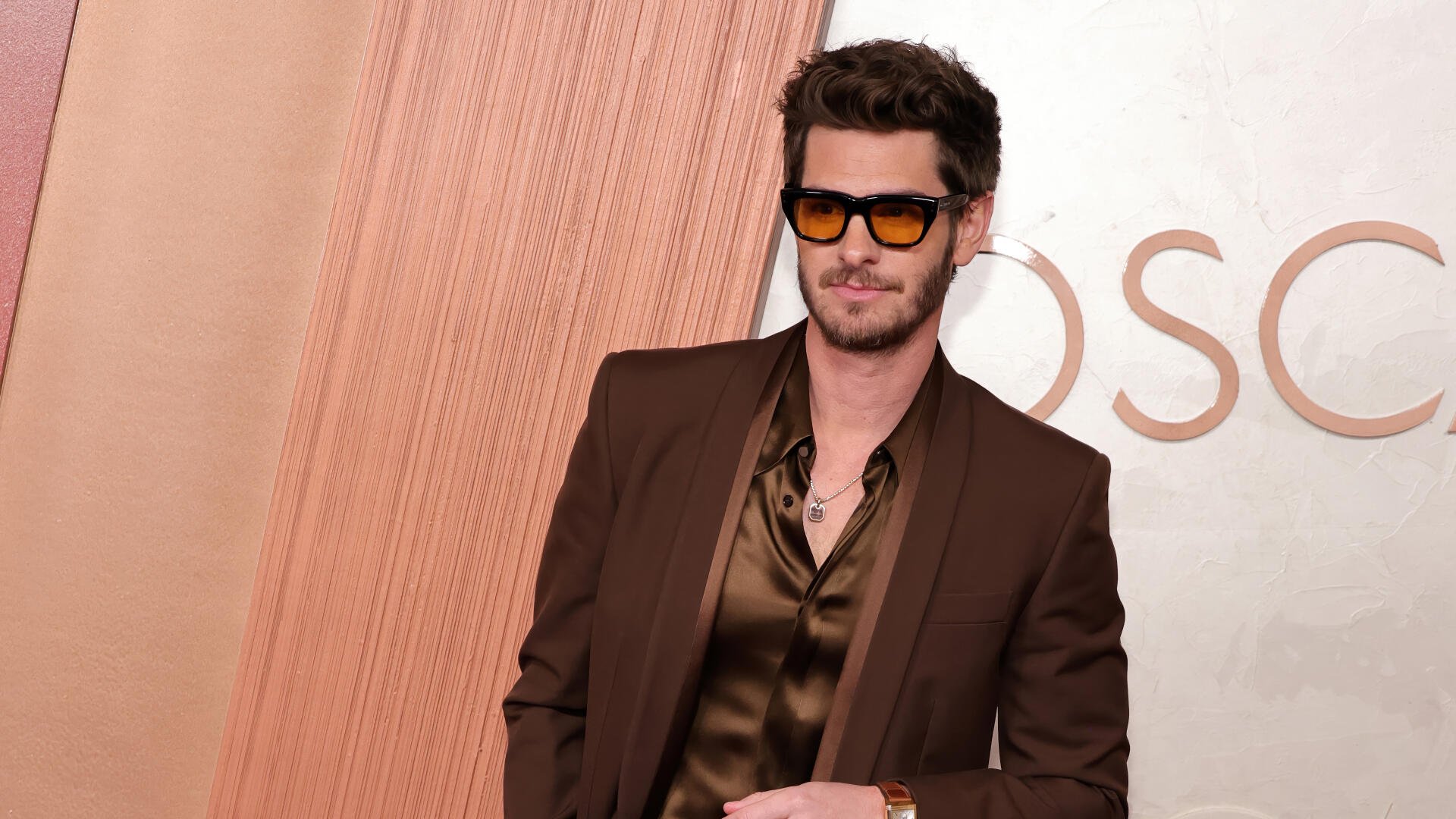 Andrew Garfield poses confidently at the Academy Awards, wearing stylish sunglasses and a sleek outfit, captured in vibrant 4K Ultra HD for a striking desktop wallpaper.