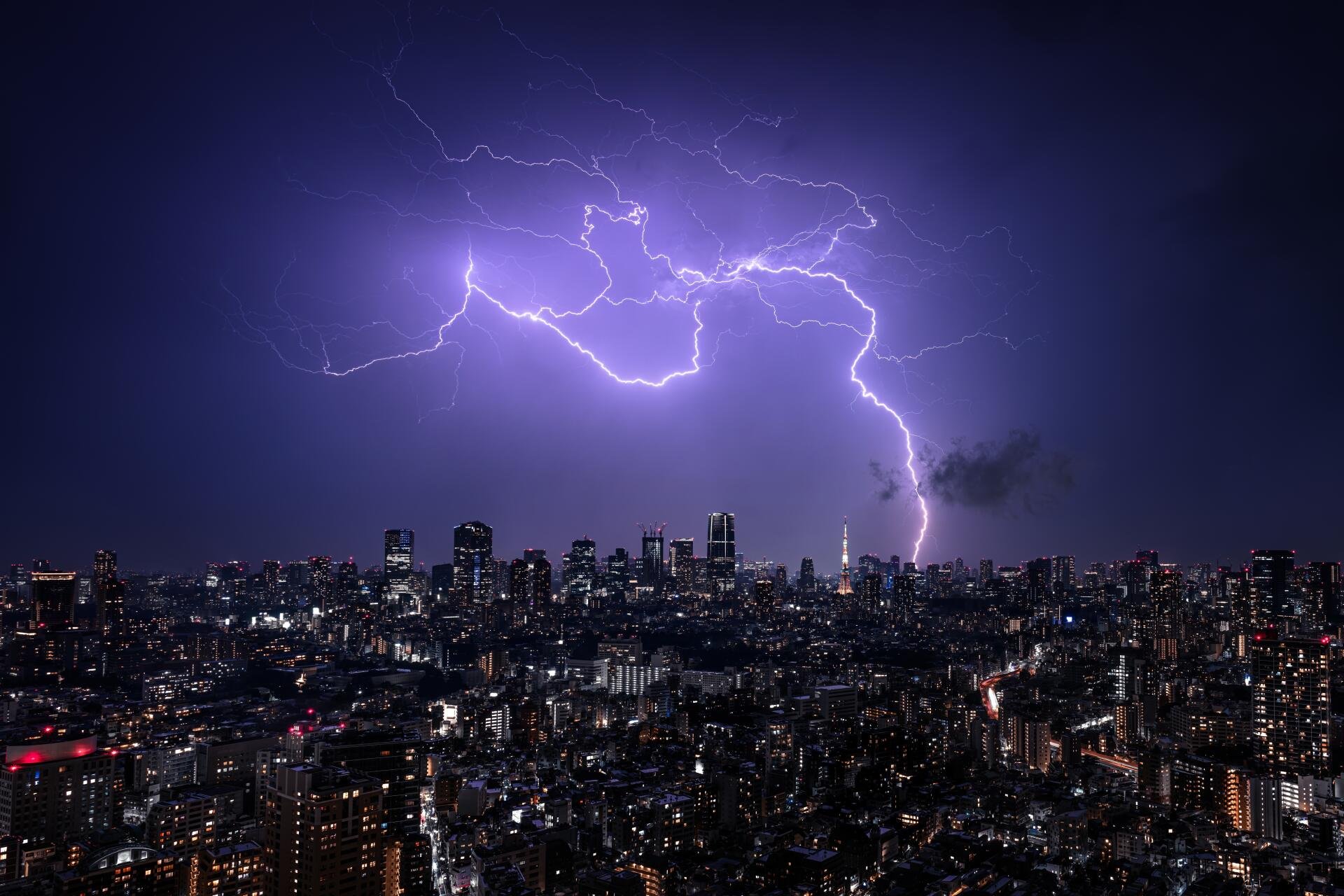 4K Ultra HD nightscape of Tokyo, Japan, with a dramatic lightning bolt illuminating the city skyline in a vibrant photography capture.