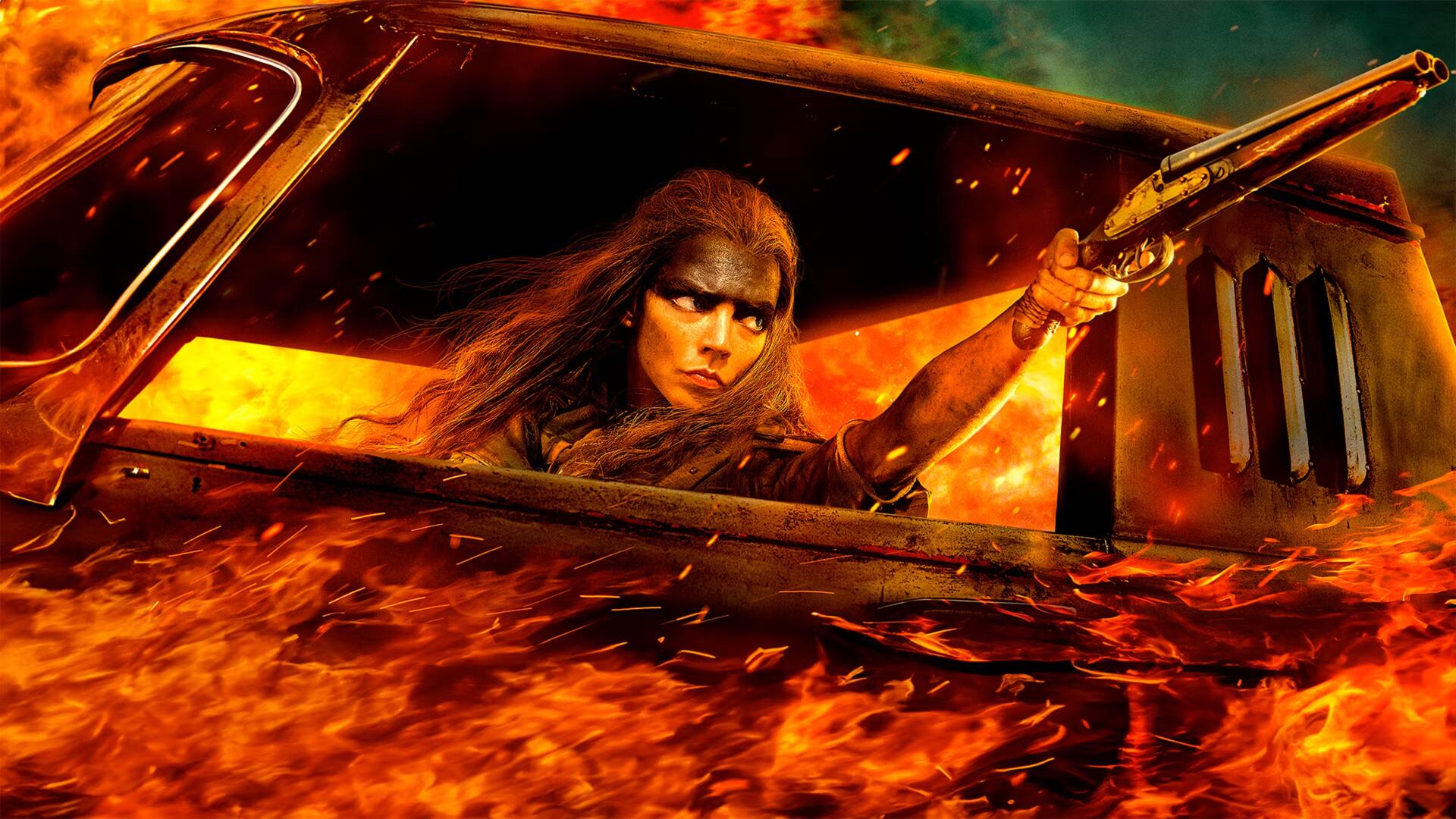 Furiosa from Furiosa: A Mad Max Saga grips a weapon, emerging from a flaming vehicle in this intense 4K Ultra HD PC desktop wallpaper and background.