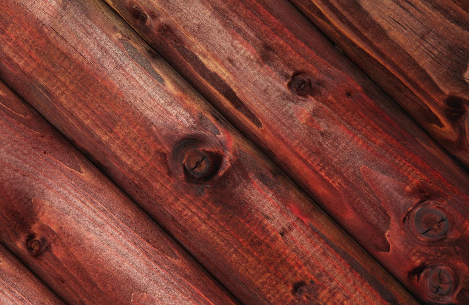 HD PC desktop wallpaper and background: close-up of red-stained wooden planks with pronounced grain and knots creating a rustic wall texture.