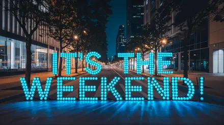 A vibrant 4K Ultra HD wallpaper featuring the text IT'S THE WEEKEND! illuminated in blue, set against a lively city backdrop at night.