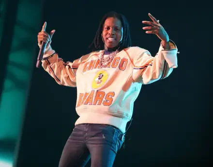 A vibrant HD desktop wallpaper featuring rapper Lil Durk performing on stage, dressed in a Chicago Bears sweatshirt, exuding energy and confidence.