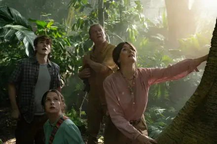 A scene from the movie Paddington in Peru, featuring four characters in lush greenery, gazing upwards with expressions of wonder, enveloped in a warm, inviting light. HD desktop wallpaper.