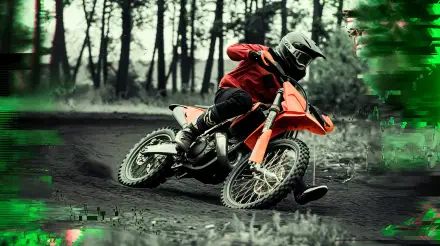A rider maneuvers a vibrant orange dirt bike on a rugged trail, surrounded by trees, captured in stunning 4K Ultra HD for a dynamic desktop wallpaper.
