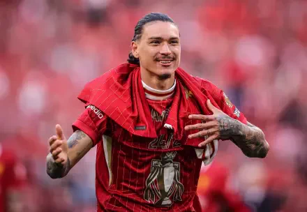 Darwin Núñez celebrating in his Liverpool F.C. jersey, surrounded by a vibrant red backdrop, capturing the spirit of Premier League soccer in this striking HD desktop wallpaper.