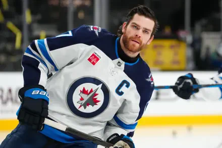 HD desktop wallpaper featuring Adam Lowry of the NHL's Winnipeg Jets in action during a hockey game.