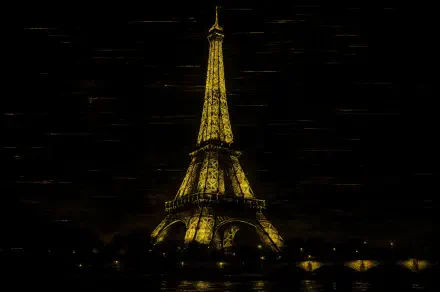 4K Ultra HD desktop wallpaper featuring the illuminated Eiffel Tower glowing against a dark night sky.