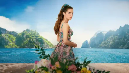 Anna Kendrick in a vibrant floral dress stands on a wooden deck overlooking a serene ocean and lush green islands, from the movie Another Simple Favor in 4K Ultra HD.