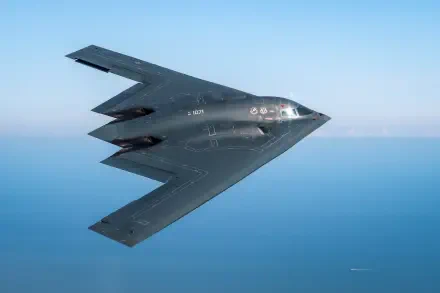 HD desktop wallpaper of a Northrop Grumman B-2 Spirit military bomber aircraft in flight over the ocean, representing advanced air force technology.