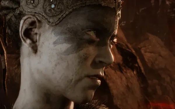 Close-up of Senua from the video game Hellblade: Senua's Sacrifice, showcasing her intense expression and detailed facial markings against a dark, atmospheric background.