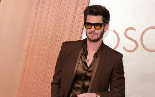 Andrew Garfield poses confidently at the Academy Awards, wearing stylish sunglasses and a sleek outfit, captured in vibrant 4K Ultra HD for a striking desktop wallpaper.