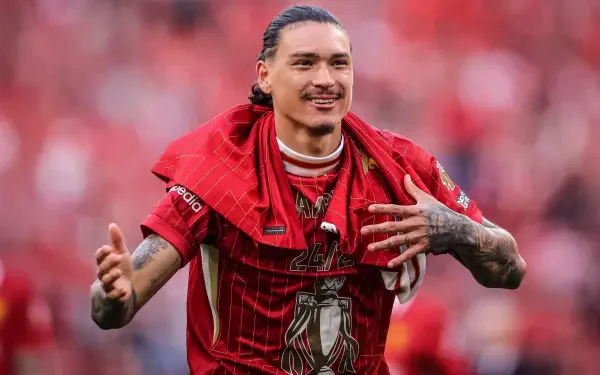 Darwin Núñez celebrating in his Liverpool F.C. jersey, surrounded by a vibrant red backdrop, capturing the spirit of Premier League soccer in this striking HD desktop wallpaper.