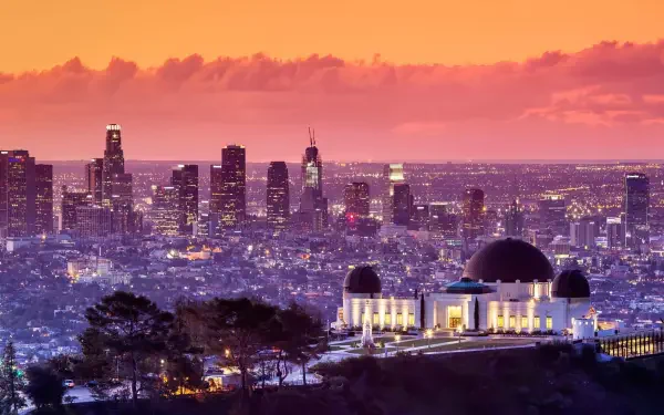 A 4K Ultra HD desktop wallpaper featuring the Los Angeles cityscape at sunset with the illuminated Griffith Observatory in the foreground.