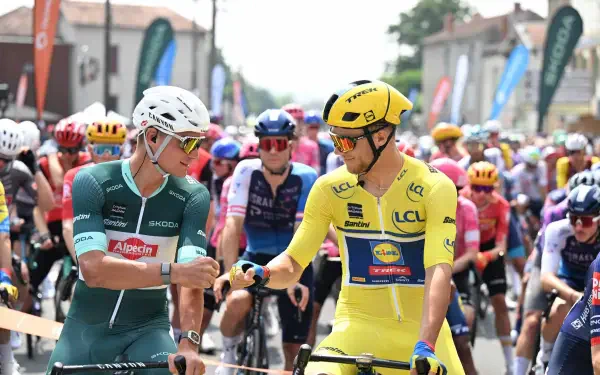 Cyclists in colorful gear exchange fist bumps during the Critérium du Dauphiné, captured in vibrant 4K Ultra HD for a dynamic sports desktop wallpaper.