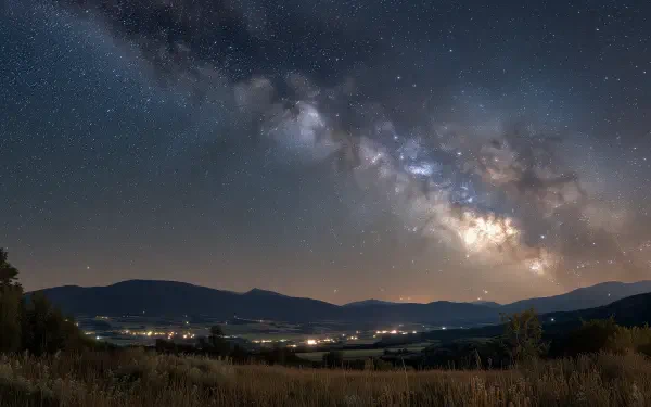 HD PC desktop wallpaper: Milky Way and stars blaze across a clear night sky over a quiet valley — nature stargazing scene.