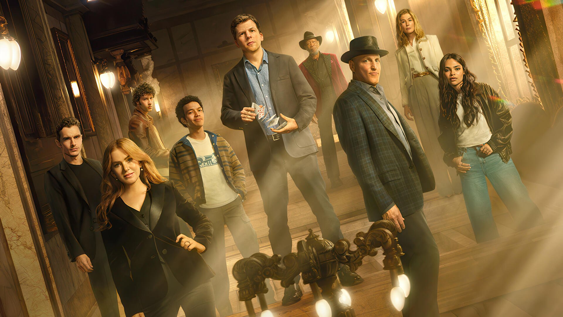 4K Ultra HD PC desktop wallpaper and background of Now You See Me 3: ensemble posed in a smoky, chandelier-lit corridor, cinematic and dramatic.
