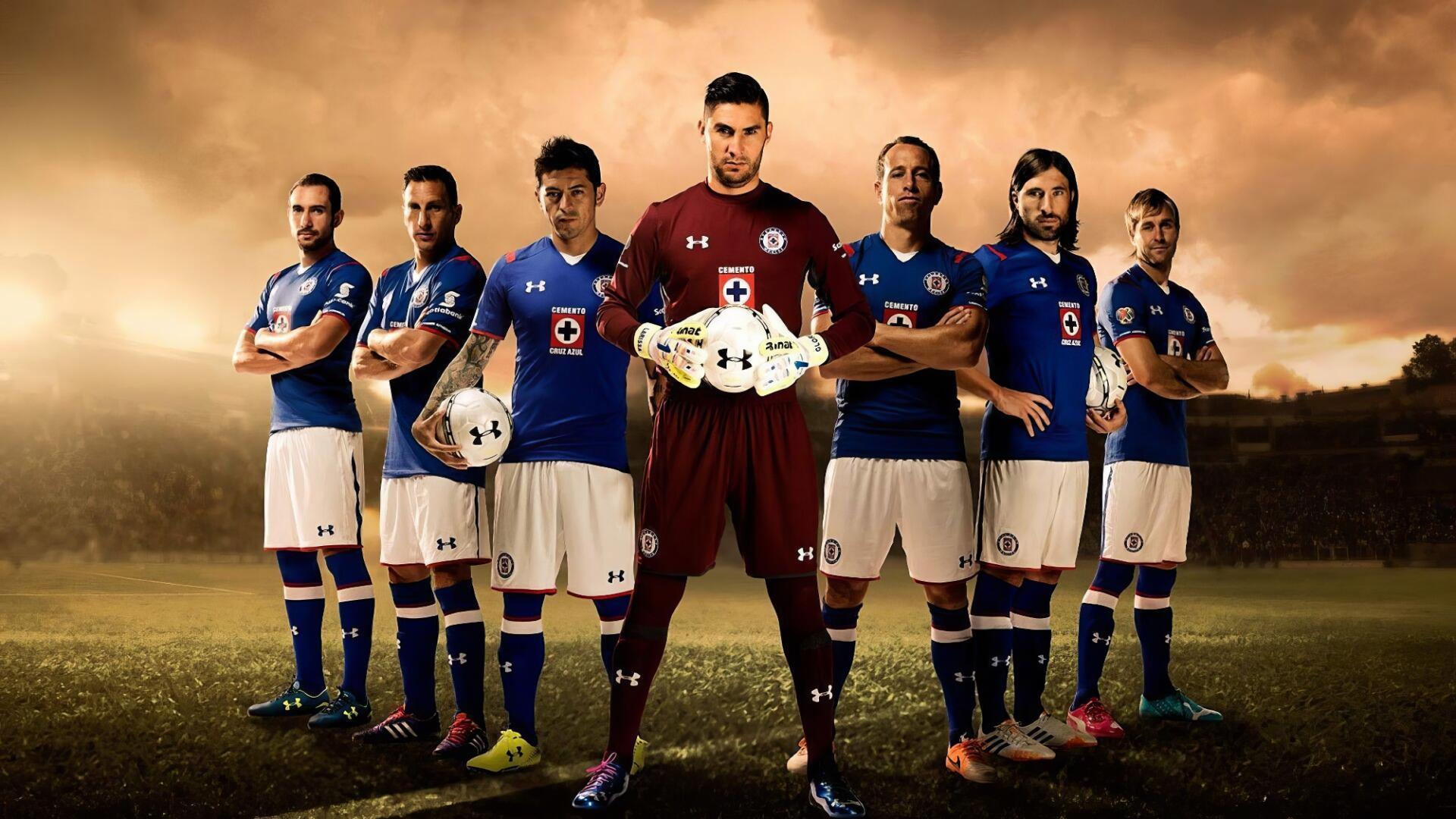 HD desktop wallpaper of Cruz Azul soccer goalkeeper in maroon, holding a ball and standing with teammates in blue kits on a dramatic stadium background.