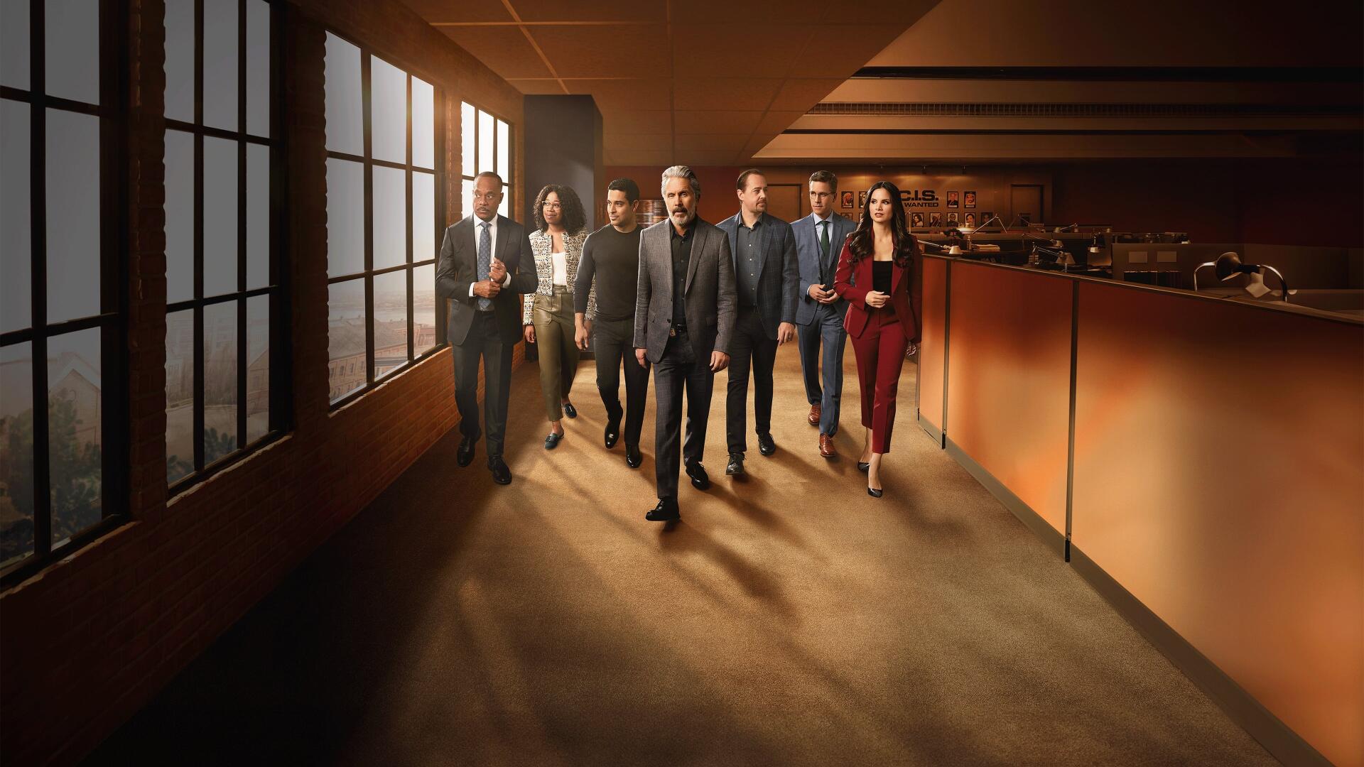 NCIS team walking through a sunlit office corridor — cinematic 4K Ultra HD PC Desktop Wallpaper and Background with warm tones and long shadows.
