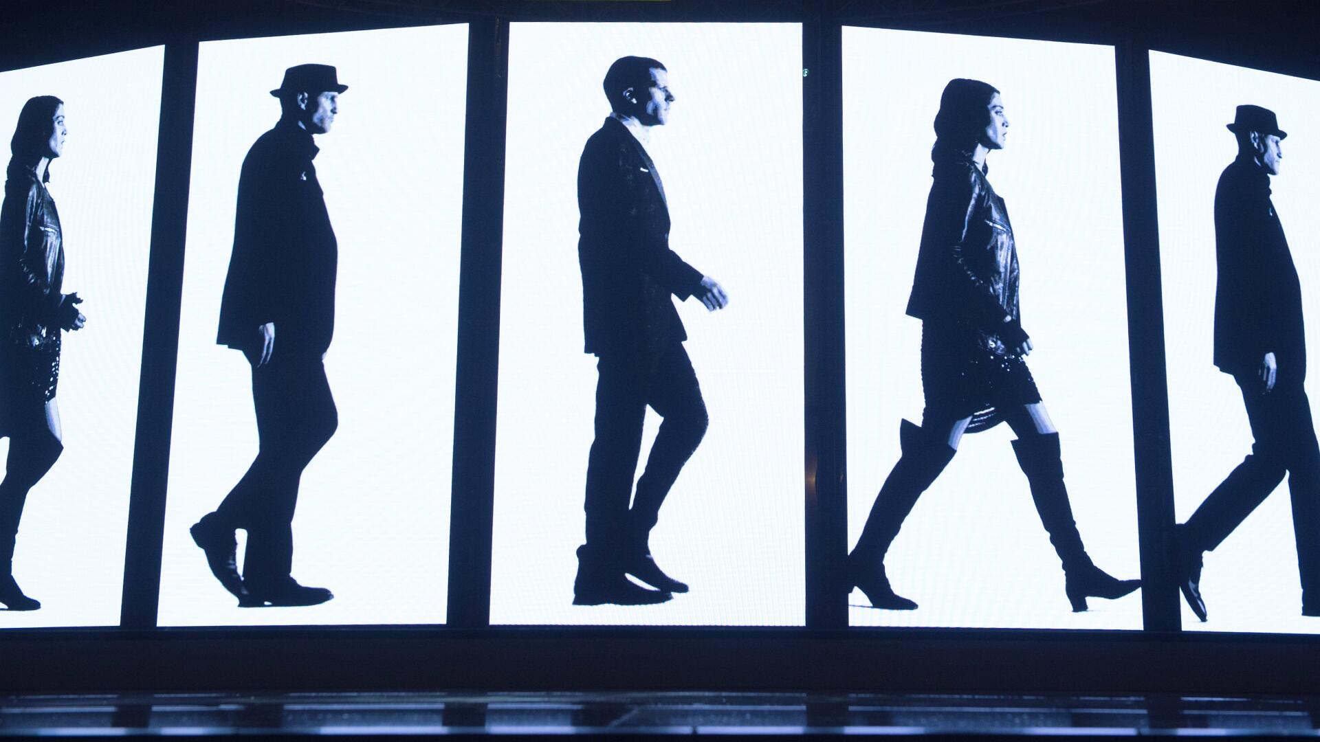 Now You See Me 2 4K Ultra HD PC desktop wallpaper: black-and-white silhouettes of four people walking across illuminated vertical panels.