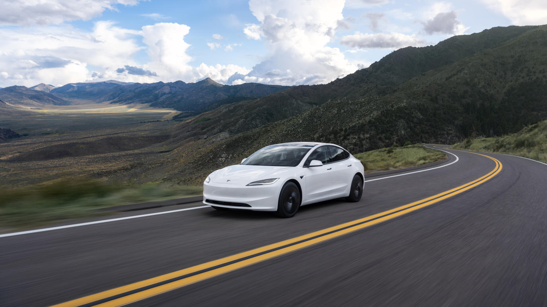 White Tesla Model 3 cruising a winding mountain road, 4K Ultra HD PC desktop wallpaper background.