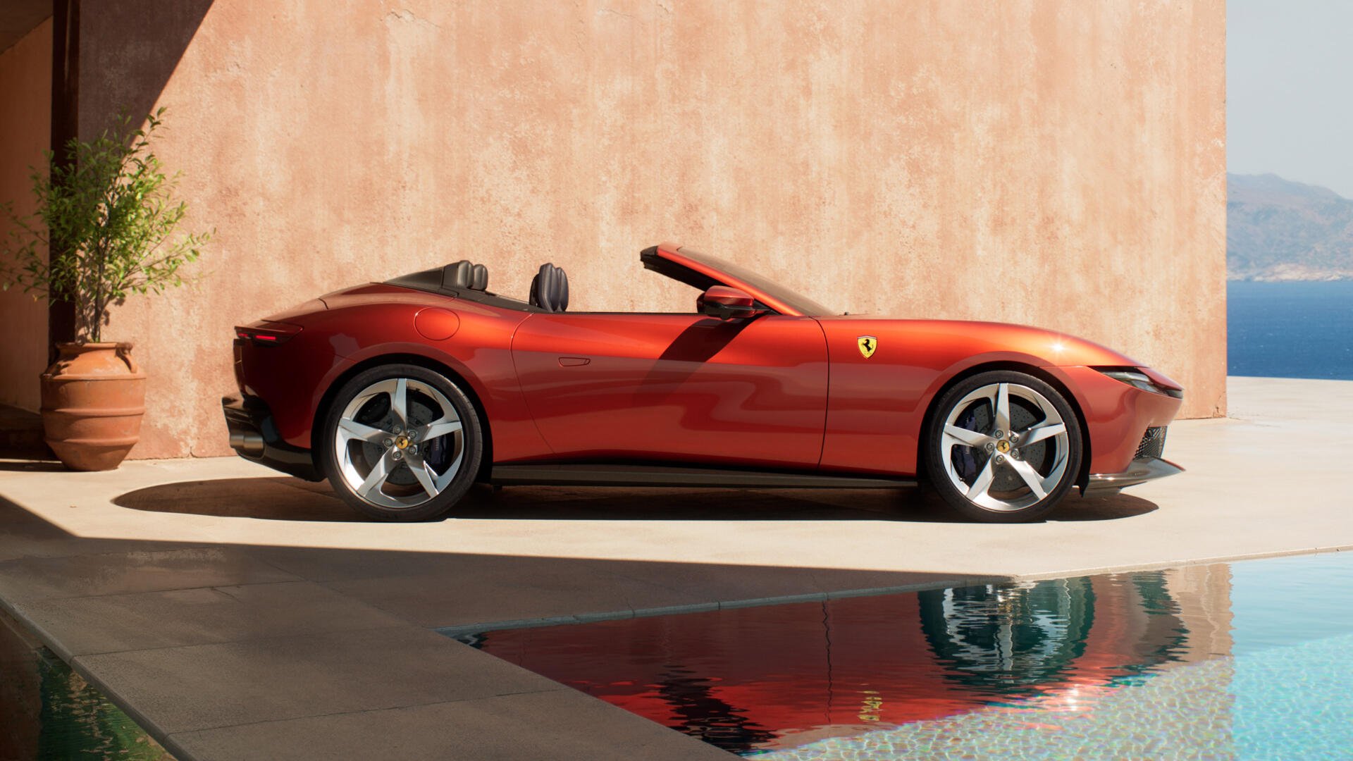 Red Ferrari Amalfi Spider convertible parked by a pool with sea view and reflection, shown as a 4K Ultra HD PC desktop wallpaper and background.