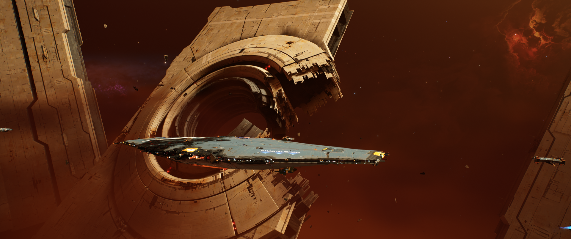 Homeworld video game scene: sleek capital ship glides by a massive ringed station in red space — 2K Quad HD PC desktop wallpaper/background