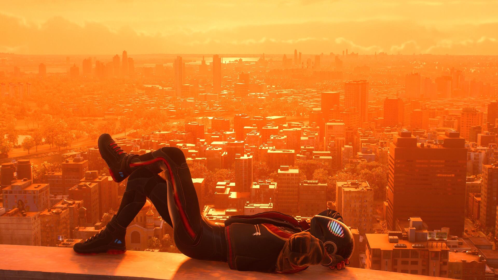 4K Ultra HD PC desktop wallpaper/background from the video game Spider-Man (PS4): Spider-Man lies on a rooftop at sunset, bathed in warm orange light as the city skyline stretches below.