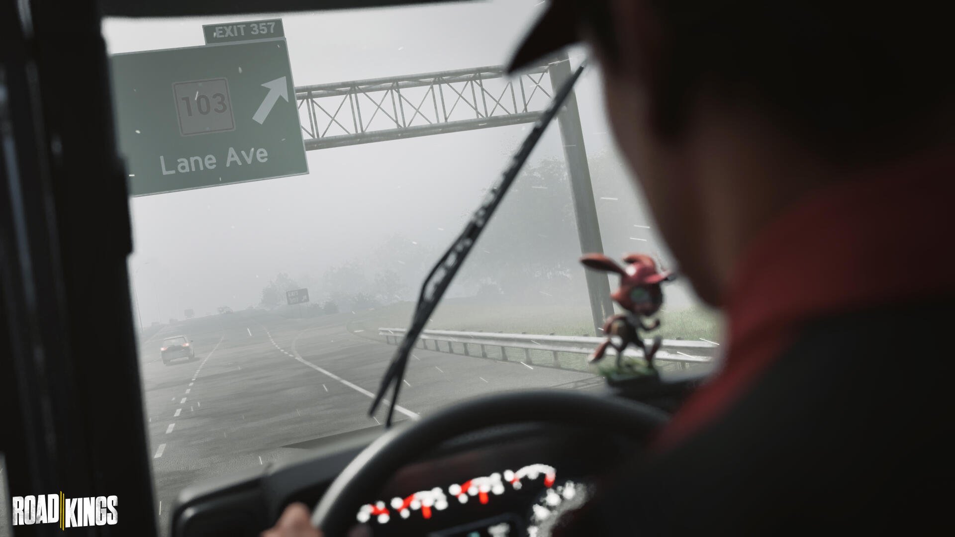Road Kings video game: driver-view through rain-smeared windshield on a highway, dashboard figurine in foreground, 4K Ultra HD PC desktop wallpaper/background.